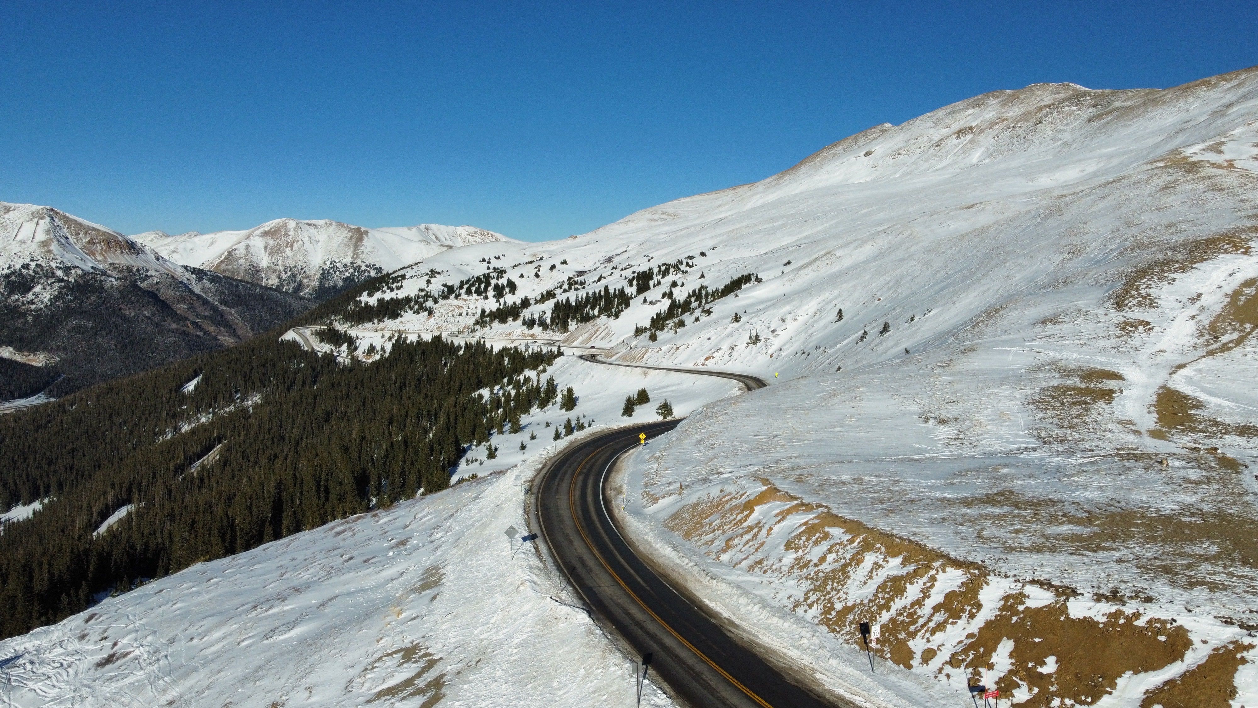A road winding between snow-covered mountain slopes