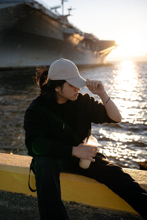A woman sitting on a bench near a ship