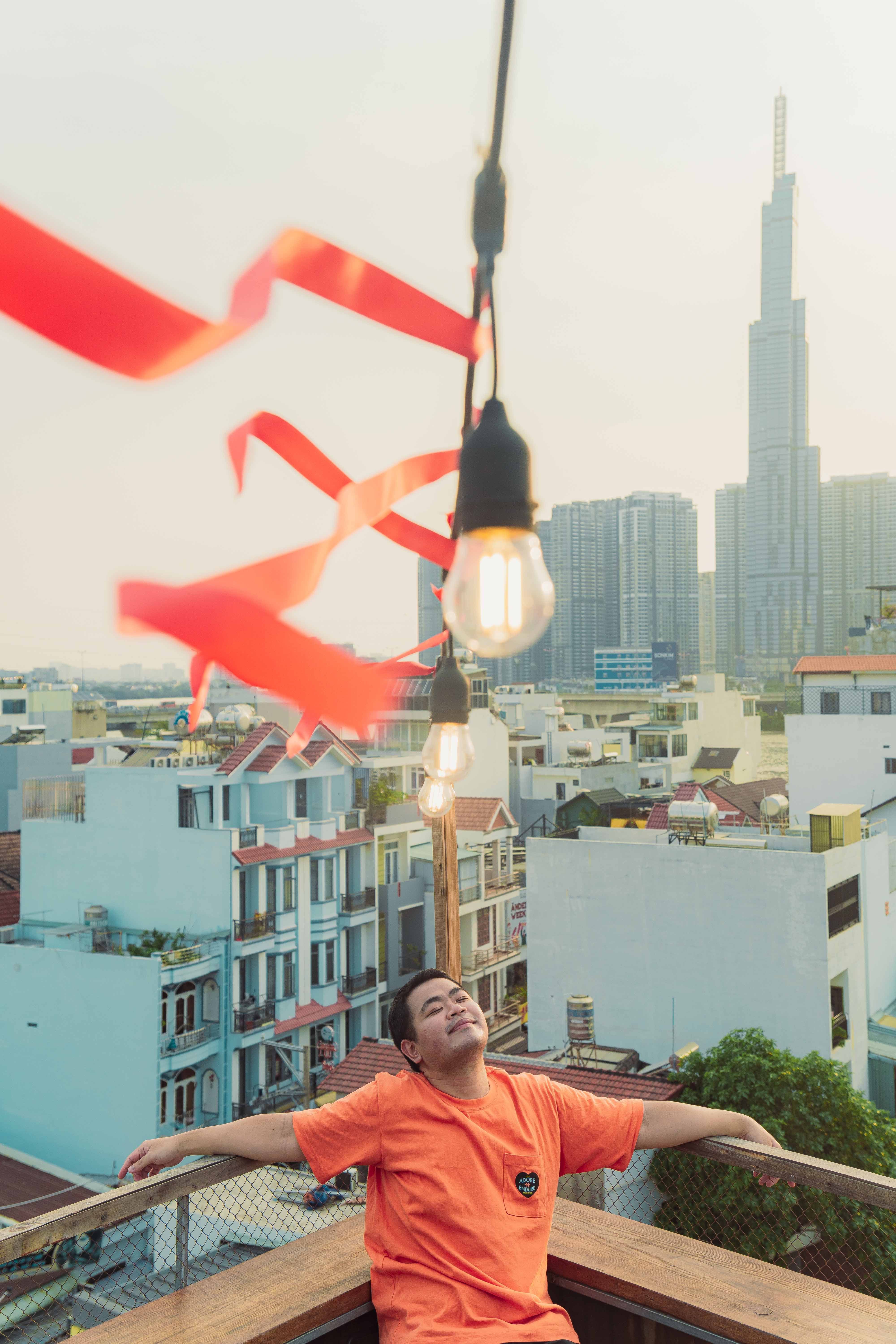 Man enjoying a rooftop view in Ho Chi Minh City with skyscrapers in the background.