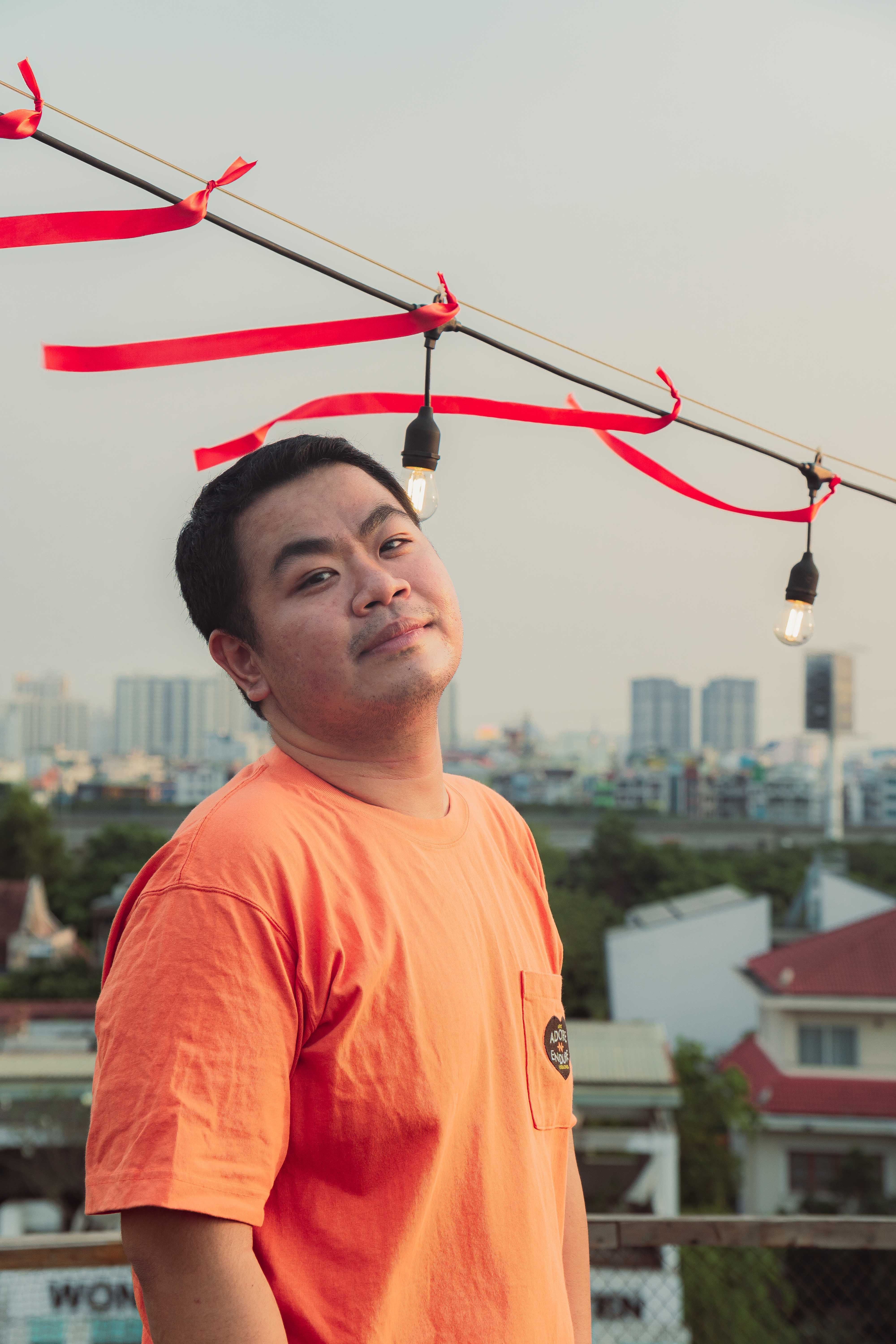 Casual portrait of an Asian man wearing an orange t-shirt in Ho Chi Minh City