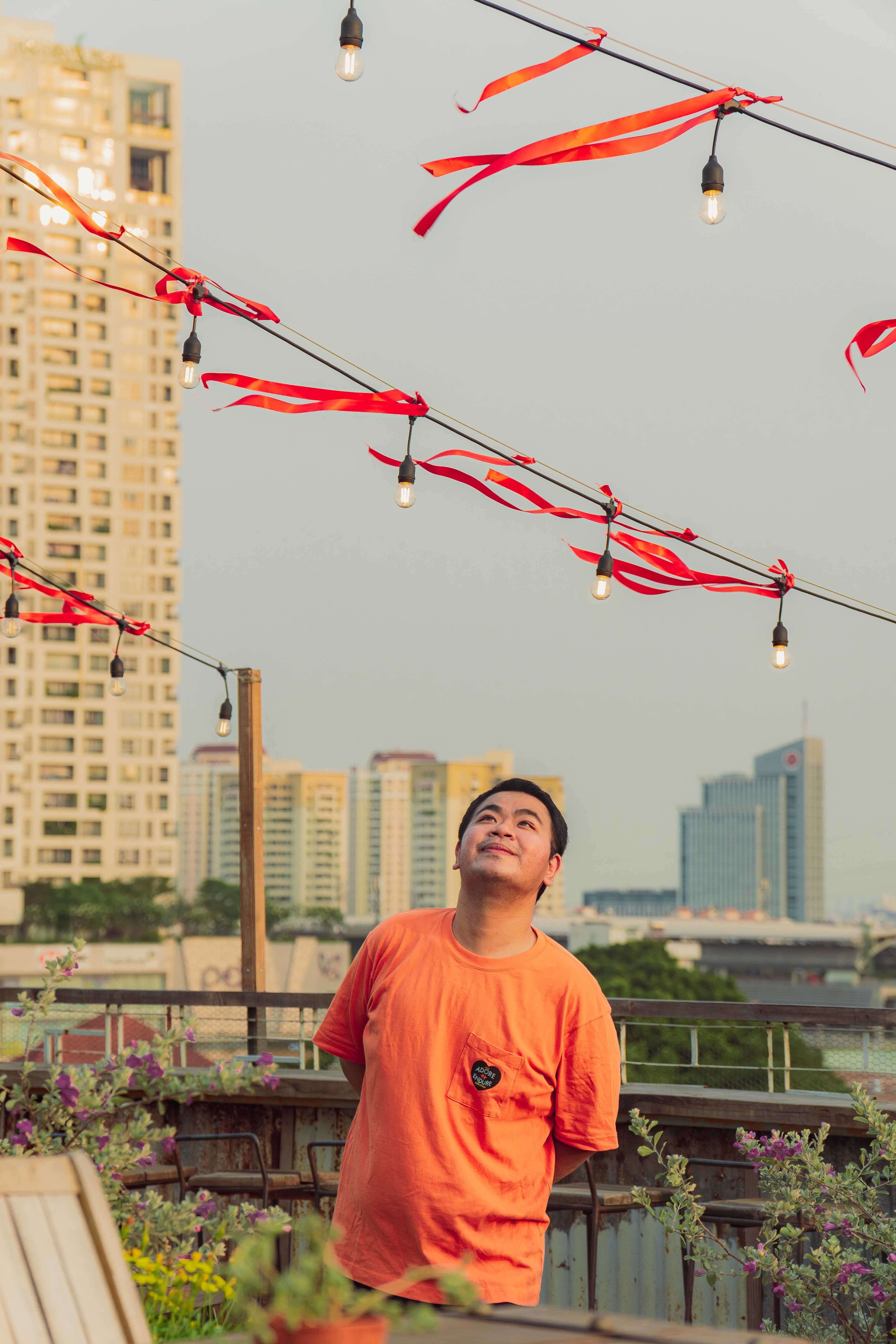 A man enjoys the rooftop view with modern skyline in Ho Chi Minh City, Vietnam, during golden hour.