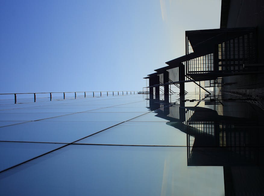 A pristine, clean commercial building facade with large windows reflecting a clear blue sky, showcasing the impact of professional cleaning - industrial pressure washing services A pristine, clean commercial building facade with large windows reflecting a clear blue sky, showcasing the impact of professional cleaning - industrial pressure washing services