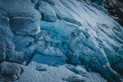 Free Majestic icy landscape capturing the intricate patterns of a frozen glacier. Ideal for adventure and nature enthusiasts. Stock Photo