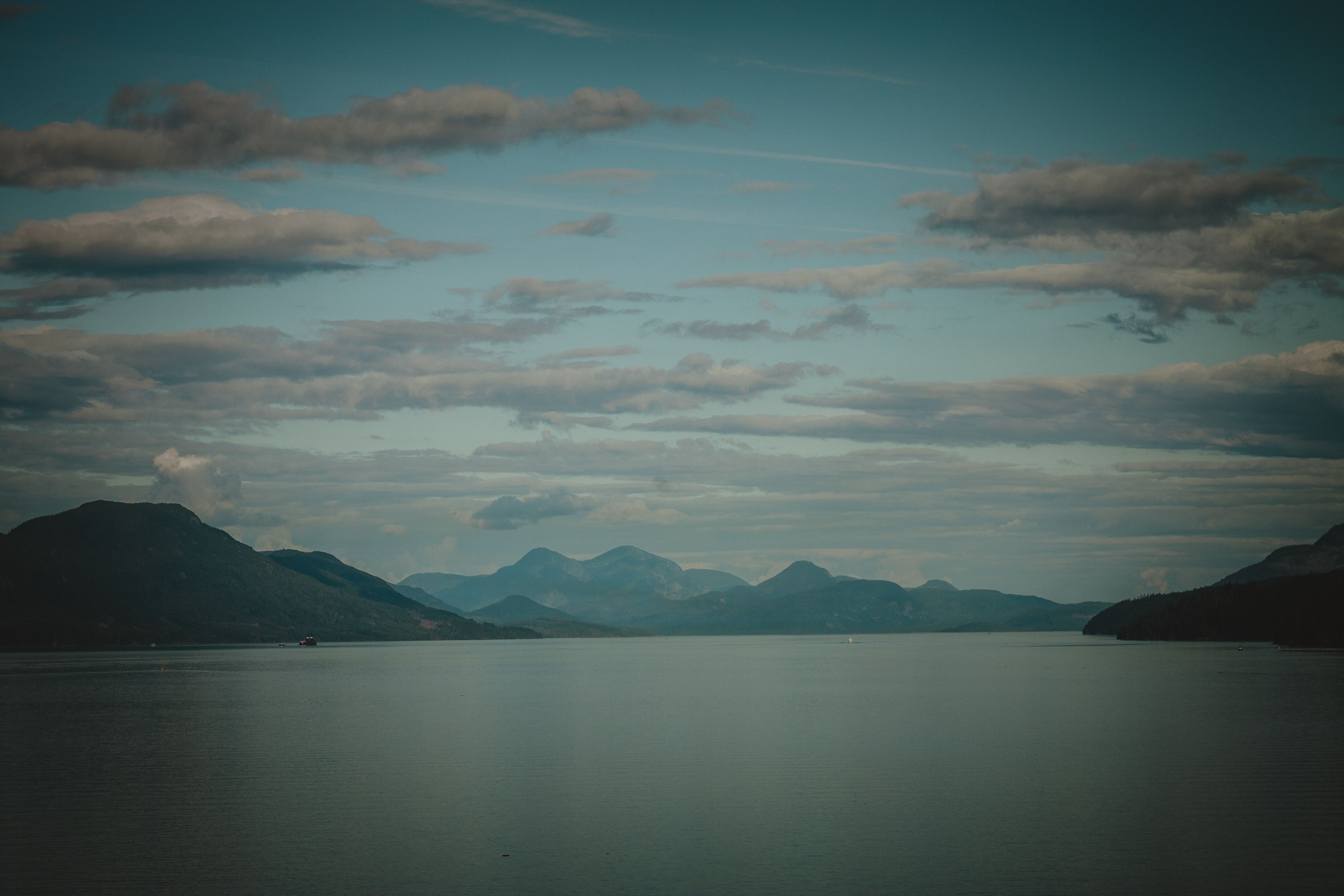 Juneau Helicopter and Dogsledding with Added Glacier Landing - Peaceful view of a mountain lake under a dramatic, cloudy sky, capturing nature's tranquility.