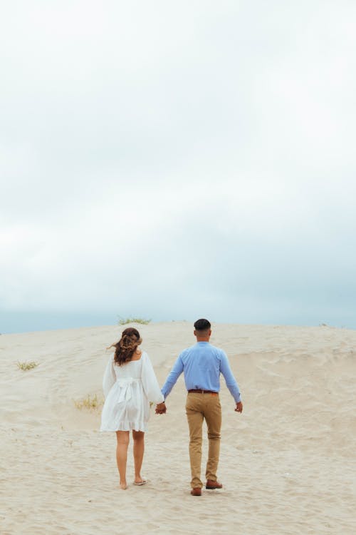 A couple walking through the sand dunes