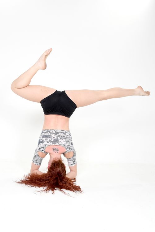 Free A woman performs a headstand showcasing strength and flexibility in a studio. Stock Photo