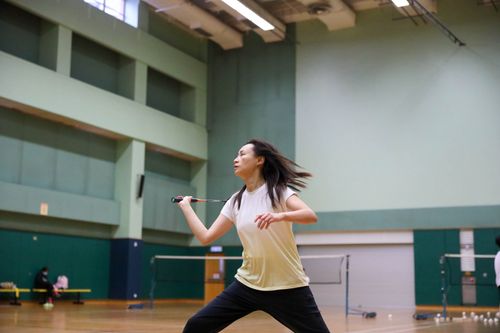 Free Dynamic action shot of a woman playing badminton in an indoor sports hall. Stock Photo