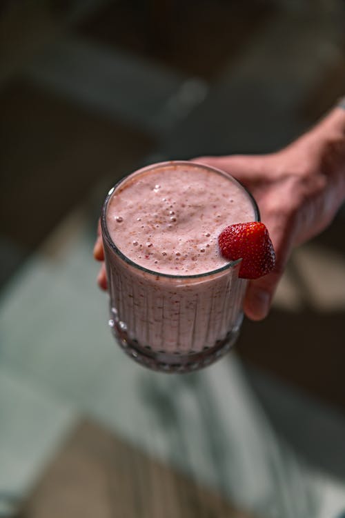 Free Close-up of a Person Holding a Glass with a Pink Drink  Stock Photo