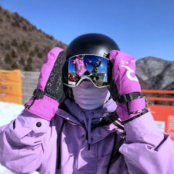 滑雪或单板滑雪者身着冬季装备，护目镜中映出山野景色