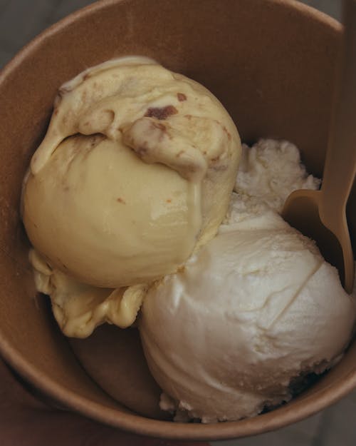 A brown paper cup with two scoops of ice cream