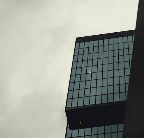 A building with a clock on it and a plane flying by