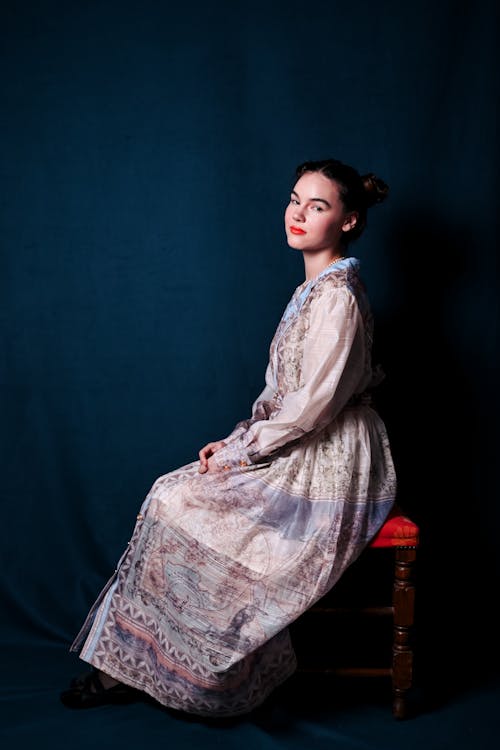 A woman in a dress sitting on a chair