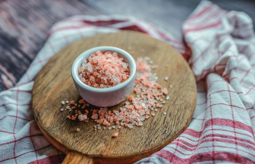 Free A close-up shot of pink Himalayan salt in a ceramic cup on a wooden board. Ideal for culinary and health visuals. Stock Photo