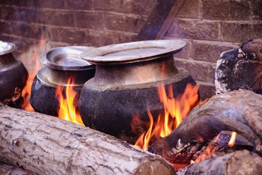 Traditional cooking setup with pots over a wood-burning fire in Srinagar, showcasing rustic culinary techniques.