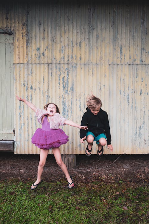 Фотография мальчика, прыгающего рядом с девушкой
