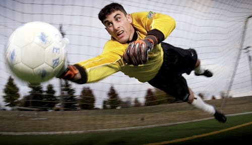 Free Man Catching Soccer Ball on Field Stock Photo