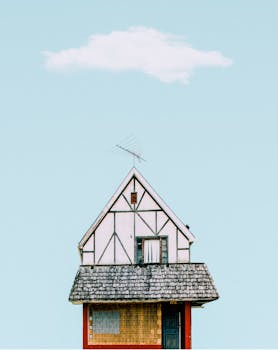 古色古香的小屋屋顶和立面映衬在晴朗的天空下，天空中只有一片云