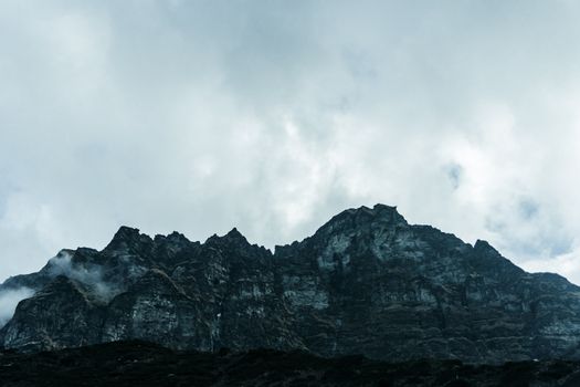 A dramatic view of Machhapuchchhre mountain under cloudy skies in Gandaki Province, Nepal.