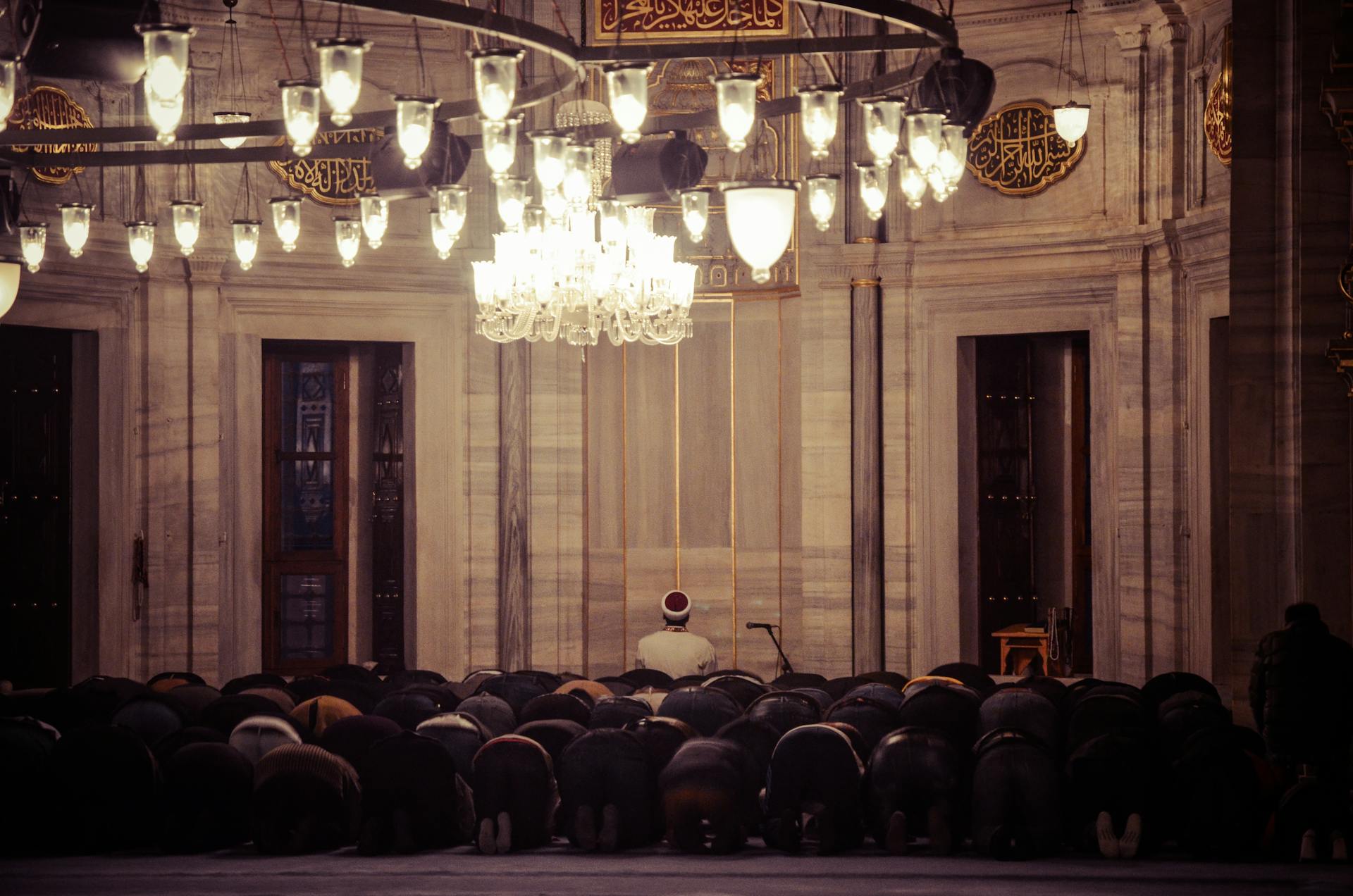 A group of worshipers praying inside a beautifully lit mosque reflecting spirituality.