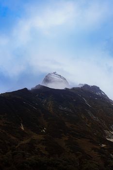 An awe-inspiring view of the Machhapuchchhre peak shrouded in fog, showcasing the majestic natural beauty of Nepal.