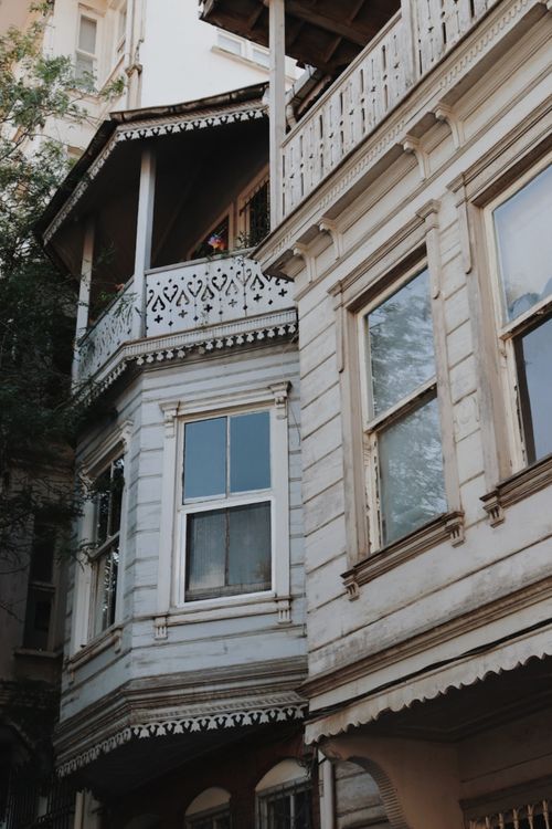 Free Close-up of ornate balconies and windows on a historic white residential building. Stock Photo