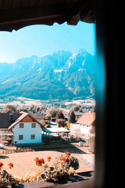 Free Picturesque view of a village with a towering mountain range in the background. Stock Photo