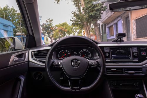 Free A view of a Volkswagen car interior highlighting the dashboard and steering wheel in an urban setting. Stock Photo