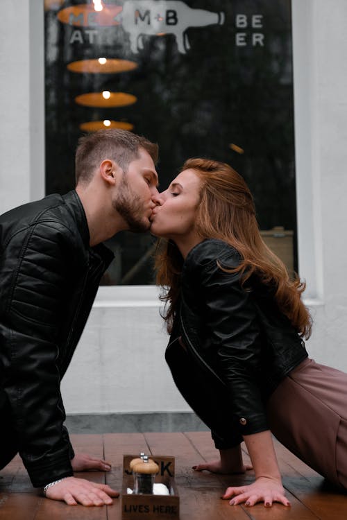 黒のジャケットを着てカップルにキス