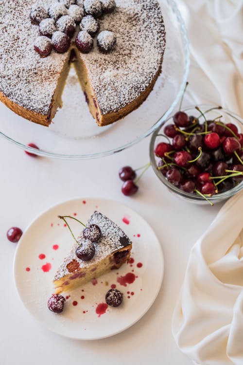 A cake with cherries on top and a slice of cake