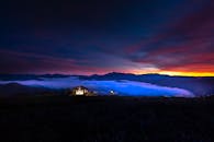 山脉上日落令人惊叹，小屋舒适明亮，天空充满活力