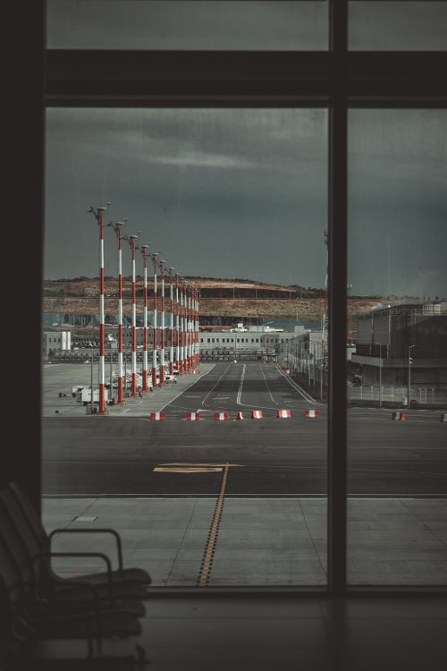 Free View from an airport lounge through large windows, overlooking an empty tarmac and streetlights. Stock Photo