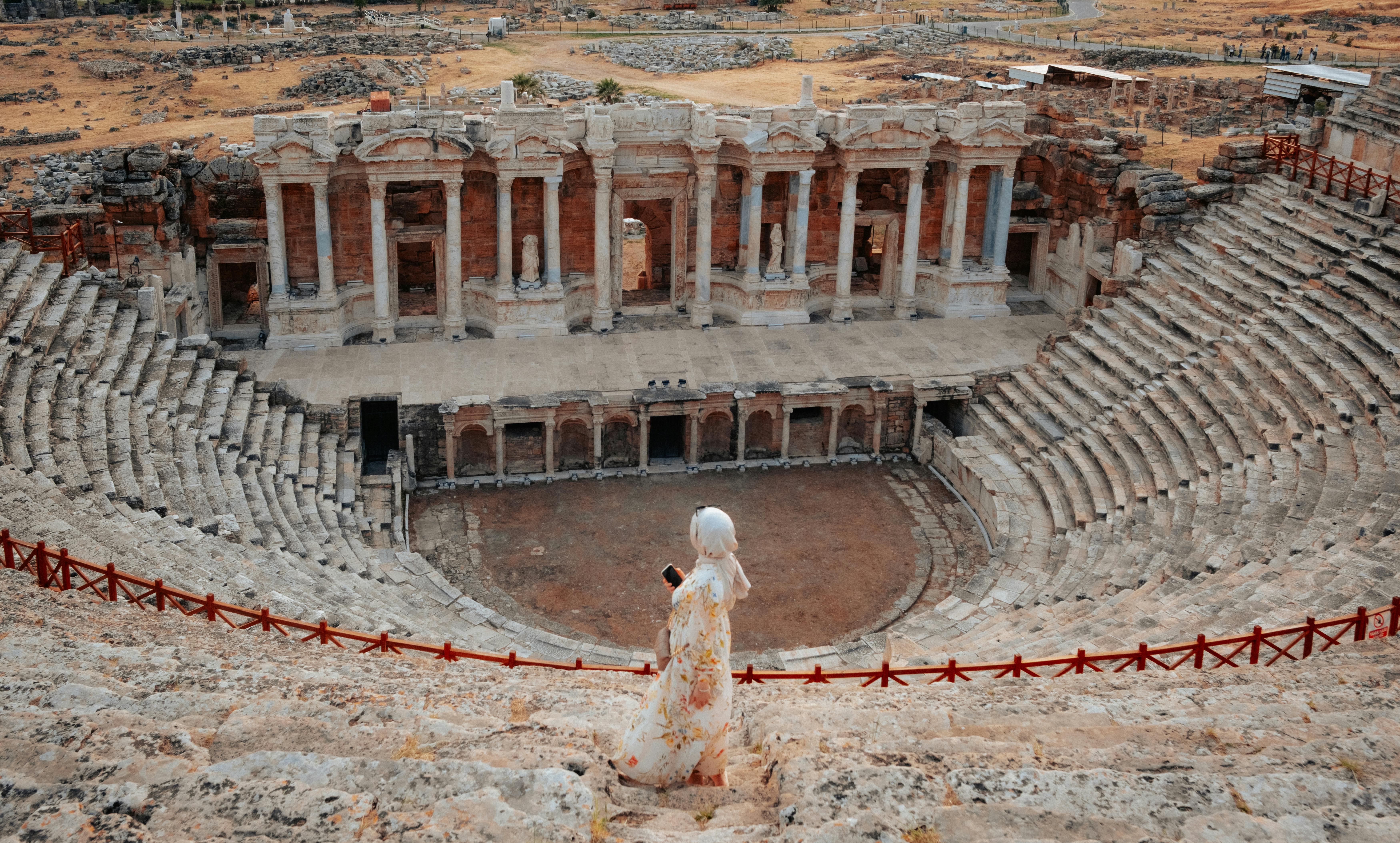 Free Woman admiring the grand architecture of the ancient Hierapolis theater in Pamukkale, Türkiye. Stock Photo