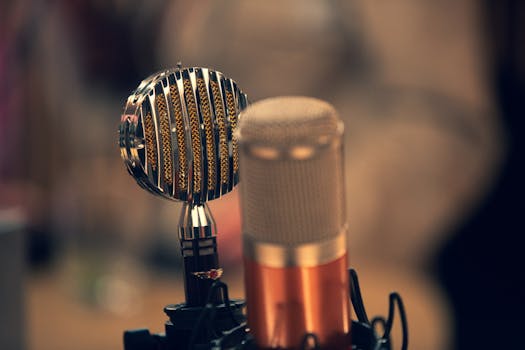 Close-up of a vintage and a modern microphone in a recording studio with a warm ambiance.