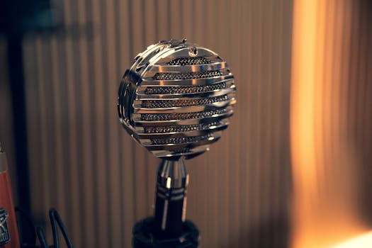 Close-up of a vintage microphone with a striped background in a studio environment.
