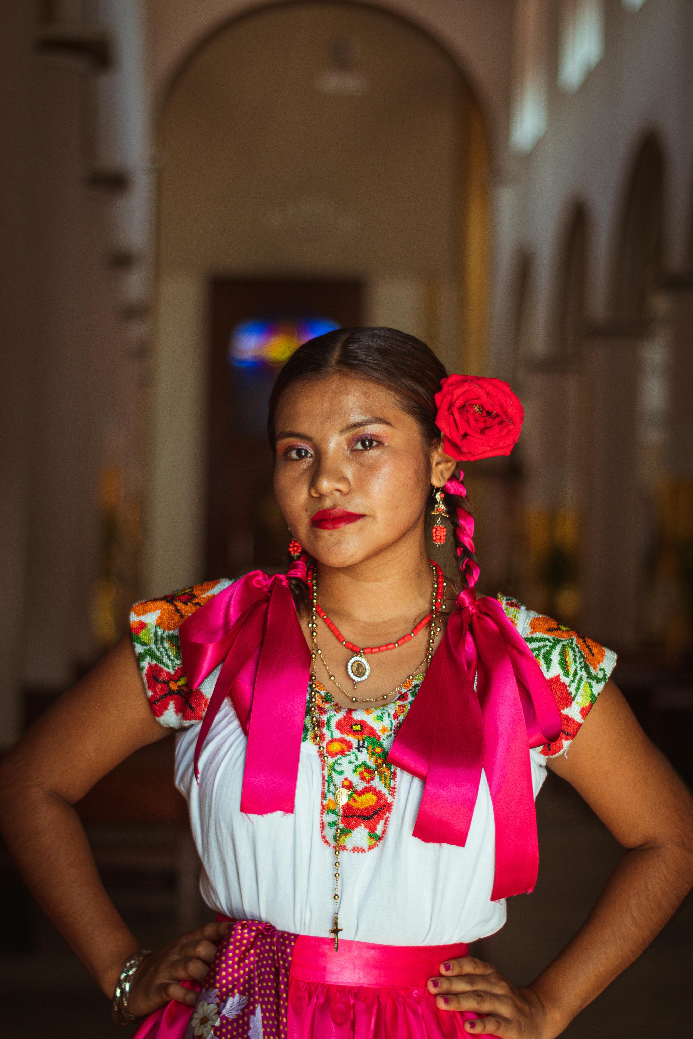 a woman in a mexican dress poses for a photo