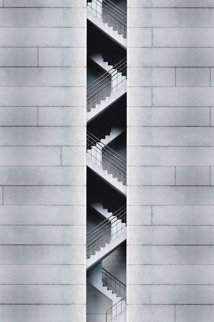 An artistic view of a modern staircase embedded in a concrete building facade in Taipei, Taiwan.