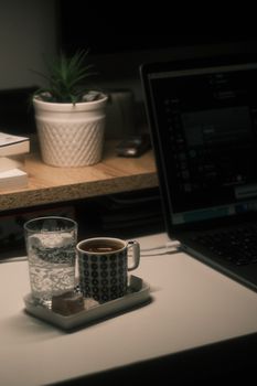 A cozy desk setup with coffee, laptop, and plant for remote working inspiration.