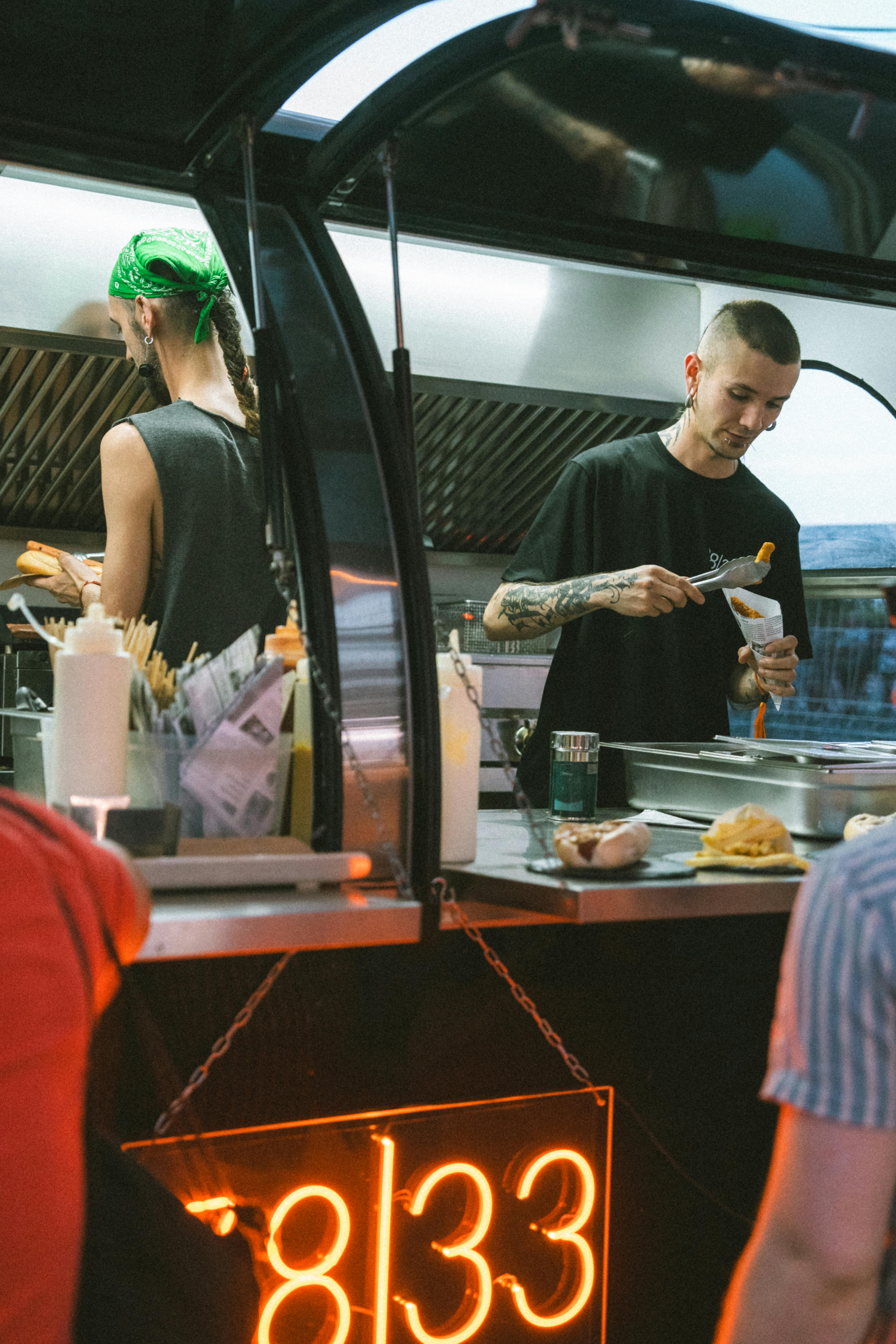 Street food vendor serving customers at a vibrant night market stall.