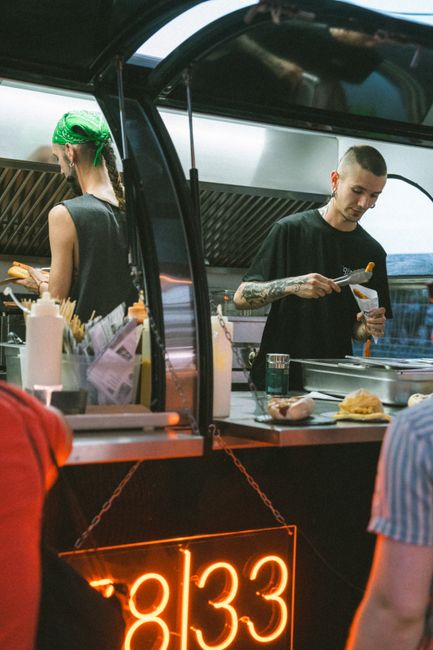 Street food vendor serving customers at a vibrant night market stall.