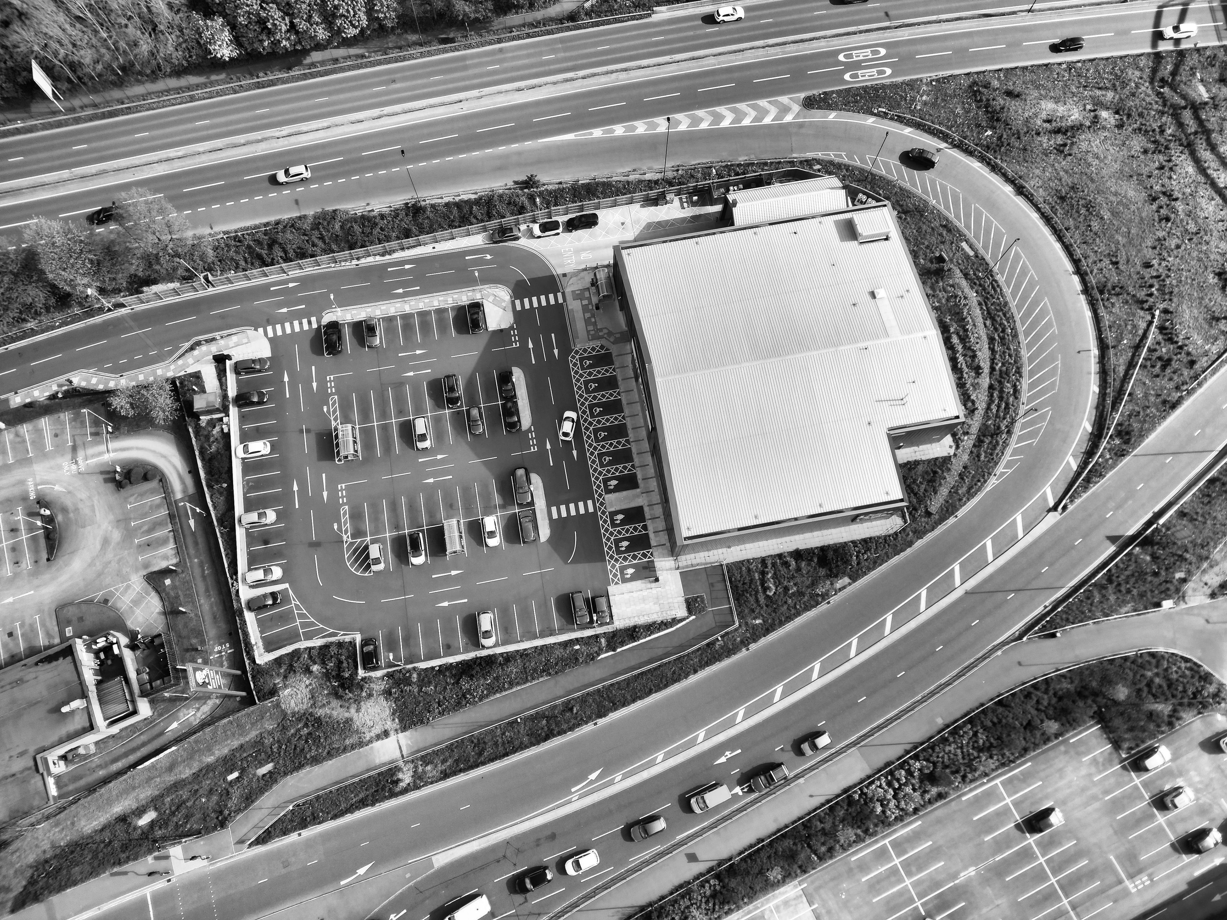 Black and white aerial view of a parking lot and surrounding roads in Derby, UK.
