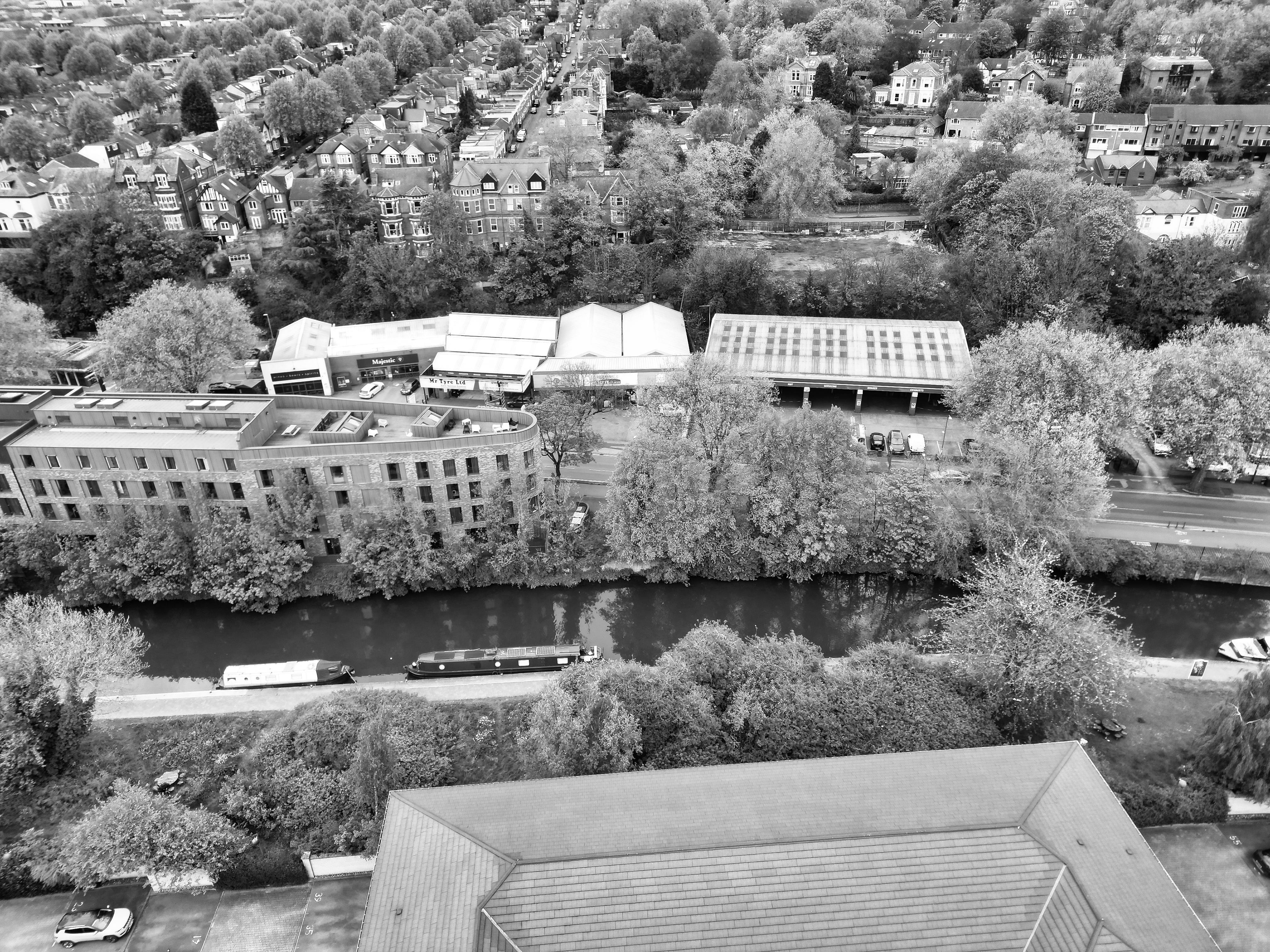 Black and white aerial view of Nottingham's canal, rooftops, and trees creating a classic cityscape.