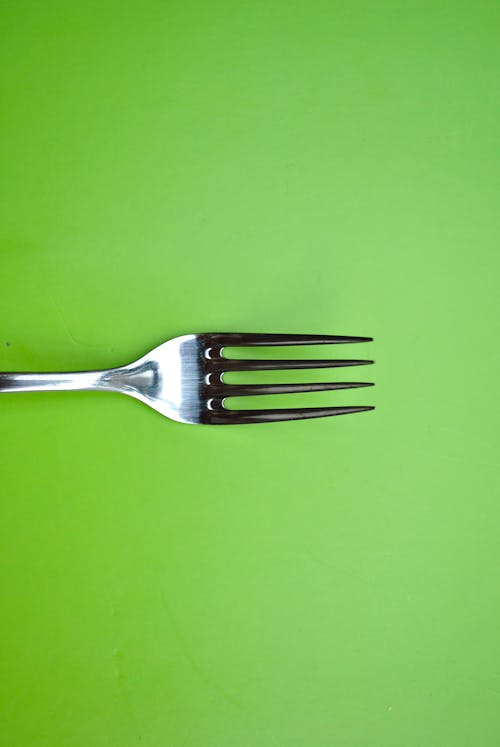 Free Stainless Steel Fork on Green Paper Stock Photo