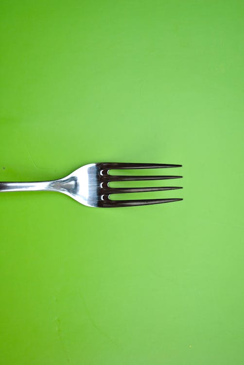 Stainless Steel Fork on Green Paper