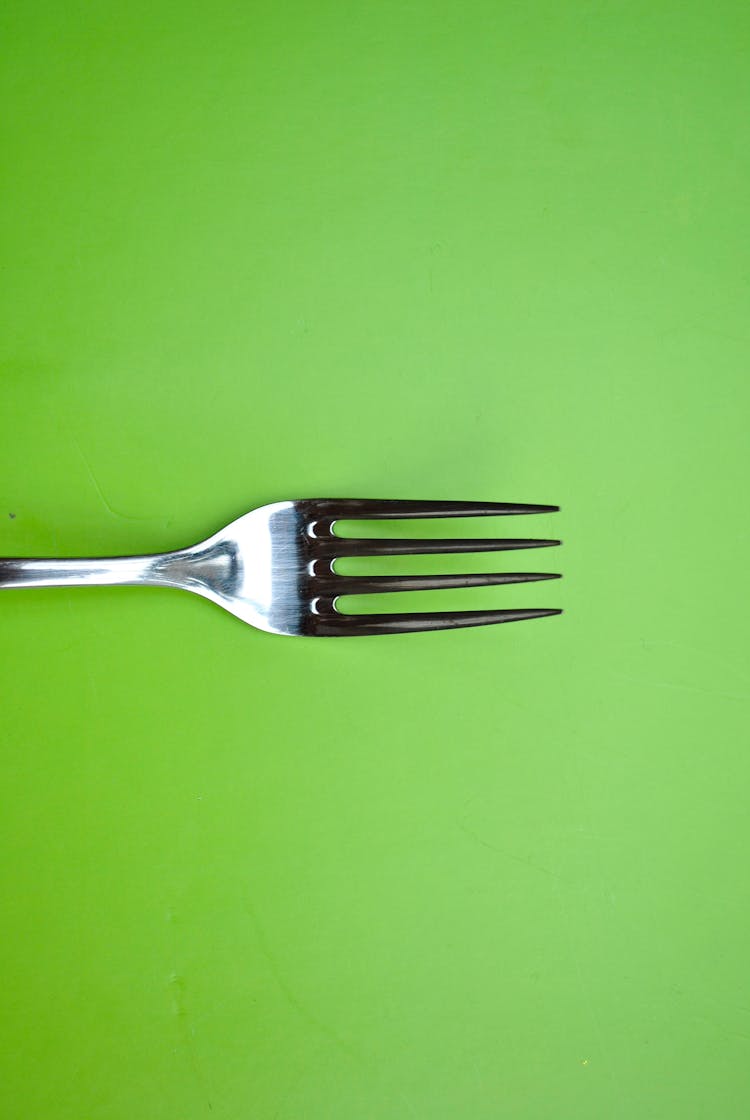 Stainless Steel Fork On Green Paper