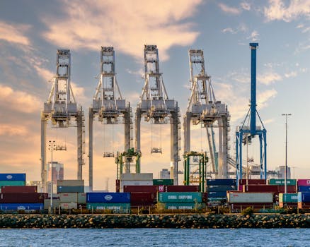 A vivid illustration of port logistics with cranes and shipping containers under a striking sky.