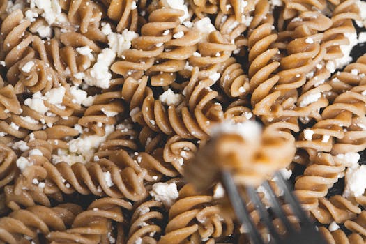 Delicious whole wheat pasta drizzled with white cheese crumbles. Perfect for food enthusiasts.