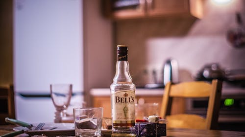 Bell's Whiskey Bottle Beside Grass on Table