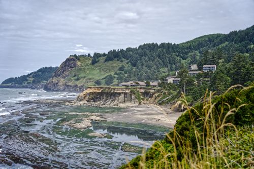 Free Breathtaking coastal landscape featuring cliffs, lush forested hills, and a serene shore. Stock Photo