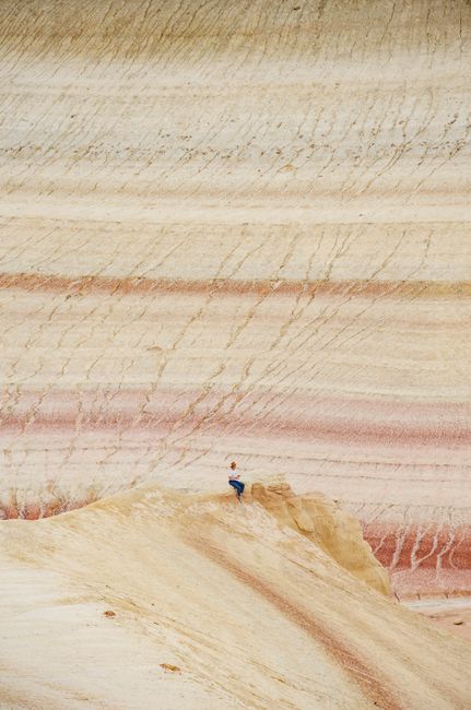 Person exploring the unique rock formations in the arid Bozzhyra desert, Kazakhstan.
