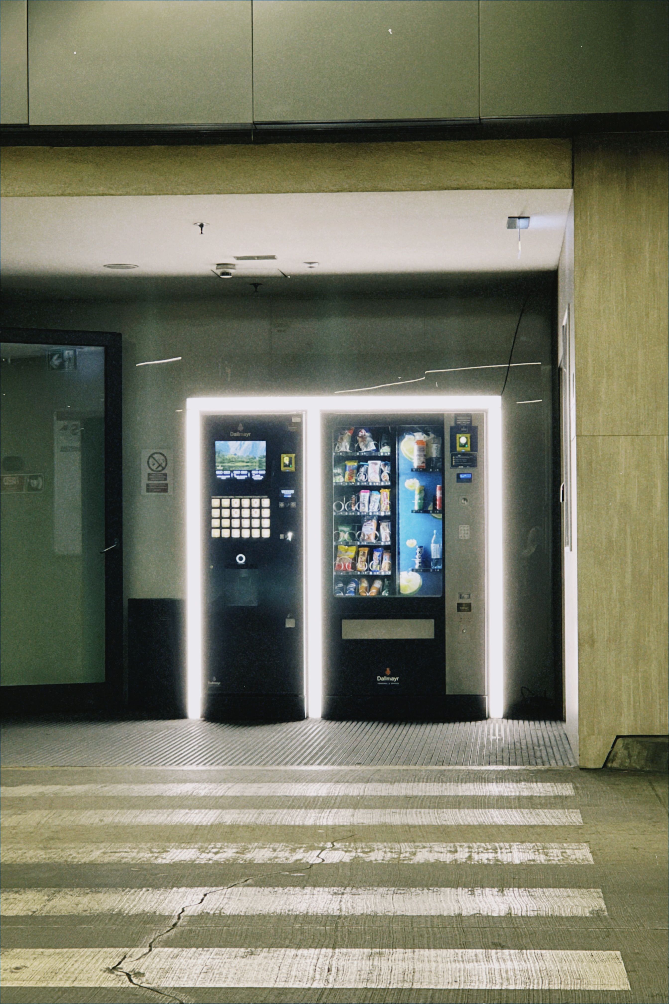 Neon-lit vending machines in a Wrocław indoor crosswalk at night.